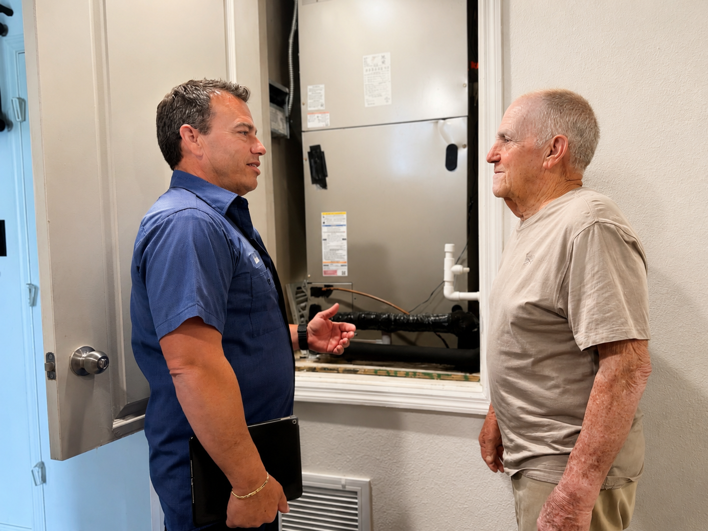 NovaComfort technician explaining a maintenance plan to a senior homeowner